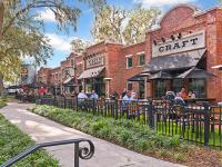 Small business and eateries near our townhomes in Popka, FL, featuring brick facades and people sitting outside dining.