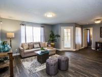 living room with vinyl wood like flooring a taupe sofa, a coffee table and two ottomans at the cove