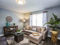 living room with vinyl wood like flooring a taupe sofa, a coffee table and two ottomans at the cove