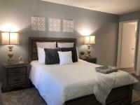 master bedroom with vinyl wood like flooring and bed with side tables and large dresser at the cove