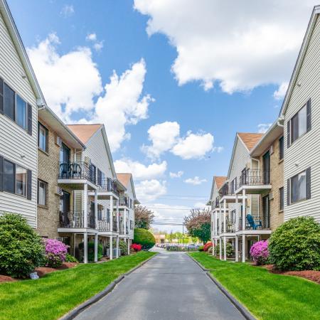 Lush landscaping and walkway between buildings  at Princeton Park apartments in Lowell, MA.