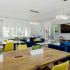 Lounge with tables, chairs, and a wall-mounted tv.