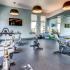 Fitness room with various cardio machines and weights.