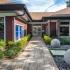 Clubhouse/Leasing Office entryway featuring tiled walk-up and stone garden