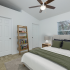 3 Bedroom - Master bedroom with bed, small book shelf, lofted ceiling and ceiling fan.