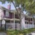 Corner of the Wisteria Downs apartment buildings lined with medium size trees and sidewalk.