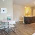 Dining area with small, circular table and three chairs.  Breakfast bar and sink in the background.
