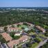 Overhead shot of the entire Lexington Crossing property, taken from a drone.  Buildings, grass, trees, pool and tennis courts are visible.