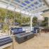 Patio seating under a pergola next to the community pool. There is a fire pit in the center of the patio set.