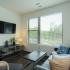 Block75 Apartments, interior, living room, couch, arm chair, large window, natural light, coffee table, wall mounted tv