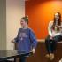 Block75 Apartments, interior, three woman laughing, two sitting on counter, one playing table tennis, orange and tan walls