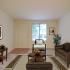 Living room with wall to wall carpet, large window, entry to townhome