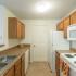 Creekside Park Apartments, interior, kitchen, wood cabinets, double sink, white appliances, stove/oven, microwave, refrigerator, dishwasher, doorway