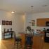 A dining area with light flooring and dark furniture and appliances. | Rental houses by Schriever SFB, Colorado Springs CO