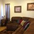 A brown wrap-around couch in front of a TV. | Rental Houses near Schriever SFB, Colorado Springs CO