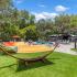 Summer Cove Apartment Homes exterior: fenced area, pool, hammocks, green turf