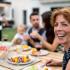 portrait of family sitting at table outdoors having a bbq