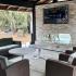 Outdoor lounge area with 70 inch tv over fire wall.