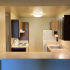 Two Bedroom kitchen with large L shaped counter white appliances and brown cabinetry.