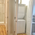 Crescendo Apartments, interior, bathroom, entrance, glass shower stall, wood flooring, laundry closet, stacked washer and dryer,