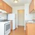 Model kitchen with modern white appliances and wood cupboards at Newport Village Apartments in Levittown, PA.