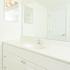 White bathroom sink and vanity with plenty of counter space and a large mirror