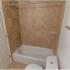 Apartment bathroom with brown tile shower and towel bar