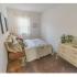 Model bedroom furnished with a large bed, dresser and nightstand at Mayflower Crossing Apartments in Wilkes-Barre, PA.