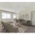 Carpeted living area with storage closet and exterior entrance furnished with grey furniture