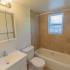Model bathroom with vanity sink, toilet and tiled tub shower at Paoli Place Apartments in Paoli, PA.