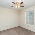 large bedroom with ceiling fan and large windows