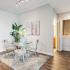 The Strand - Furnished Dining Room With a Circular Glass Table, a Set of Chairs, and Wood Flooring