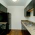 Newly renovated kitchen has laminate flooring and black appliances