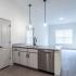The Crockett - Modern Kitchen with Breakfast Bar, Stylish Lighting, Looking into Living Area with Hardwood Style Flooring