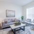 The Crockett - Living Area with Large Windows, Hardwood Style Flooring, and Balcony.