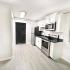 Open Concept Studio Kitchen with White Shaker Cabinets and Stainless Steel Appliances