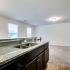 Kitchen sink overlooking the living room with wall to wall carpeting and the steps leading down.
