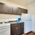 Kitchen with dark cabinets and white appliances