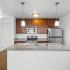 Stainless steal appliances with dark wood cabinets and lite gray granite