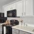 kitchen with black appliances and white cabinets