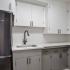 kitchen with black appliances and grey and white cabinets