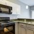 Kitchen with black appliances and white/grey cabinets