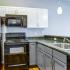 Kitchen with black appliances and white/grey cabinets