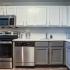 Kitchen with stainless steel appliances and grey and white cabinets