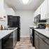 Kitchen with black appliances and grey and white cabinets
