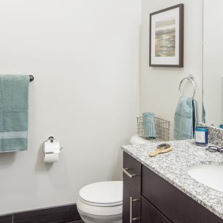 Spacious, luxury, modern bathroom with tile flooring, granite countertop