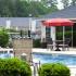 Hunters Run outdoor pool area with clubhouse and umbrella table and lounge chair.