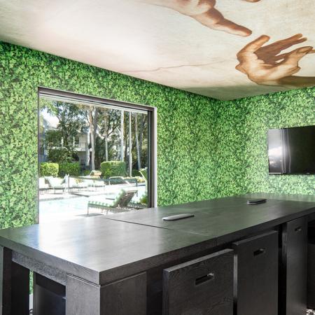 1800 The Ivy, interior, black table and chairs, green leafy wall paper, tv, window to pool area