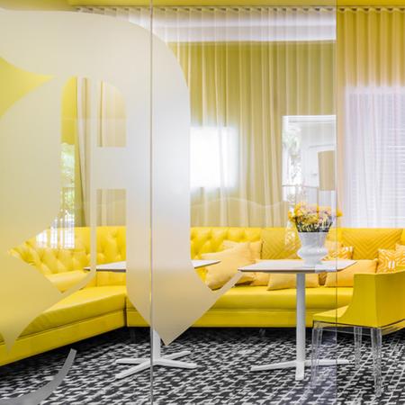 1800 The Ivy, interior, black and white carpet, large windows, glass doors, yellow walls and sectional