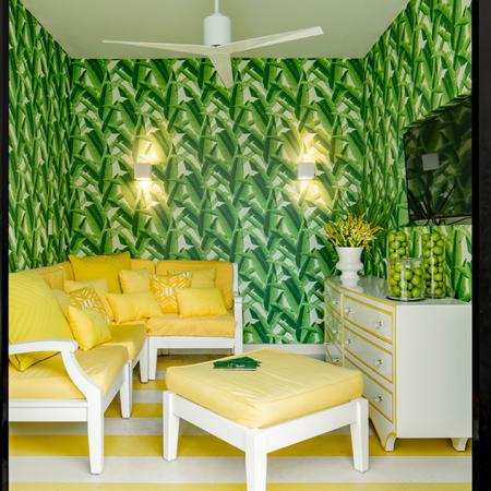 1800 The Ivy, interior, tv room, yellow and white sofa, ottoman, dresser, tv, green foliage wall paper